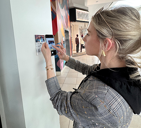 A guest scanning a walking tour placard